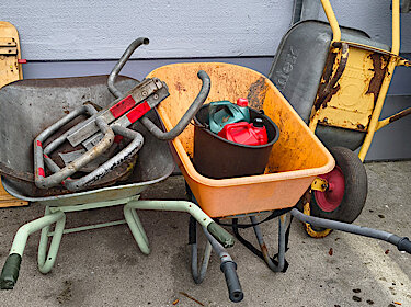 Drei Schubkarren und Metallteile